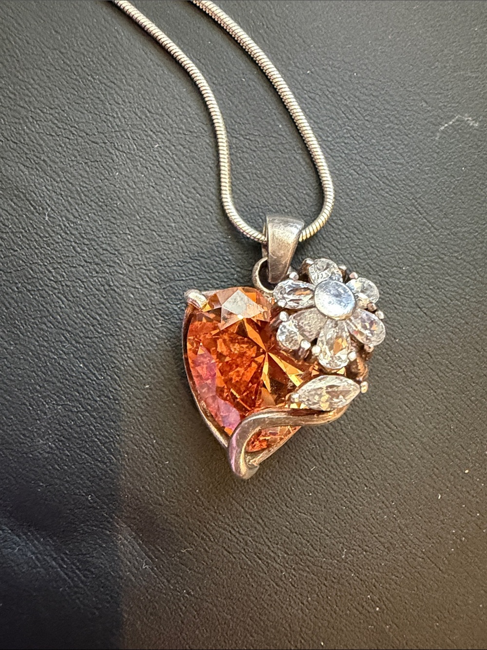 Sterling silver heart pendant features a prominent orange citrine /sapphire gem